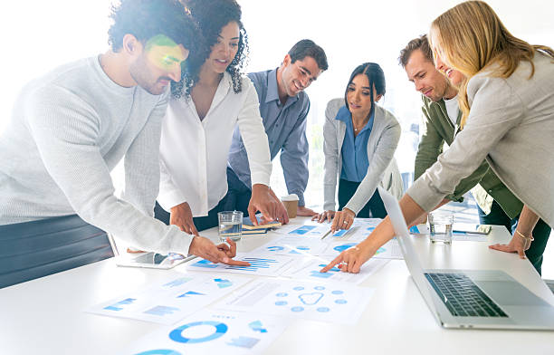 istock Financial and business documents on table with multiethnic group of people working on them. 2221552595