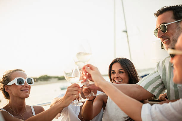 istock Friends toasting with white wine on sailboat at sunset 2221554035