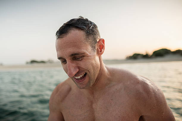 Portrait of a happy man emerging from the sea, enjoying a refreshing swim
