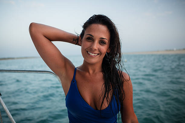 Carefree young woman enjoying a relaxing sailboat ride on the ocean