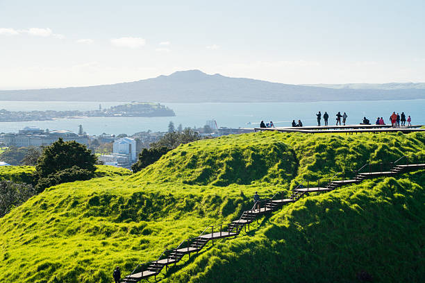 Mt Eden summit  in the foreground with tourists Rangitoto Island in the distance, Auckland, New Zealand.