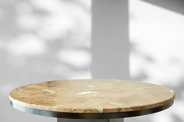 istock Round marble table top with tree leaves shadow drop on white wall background for mockup product display 2221563459