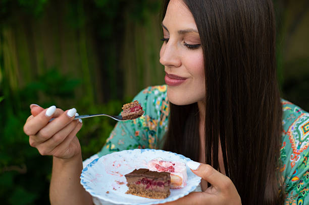 istock Young woman sitting in her back yard and eating cake 2221564152