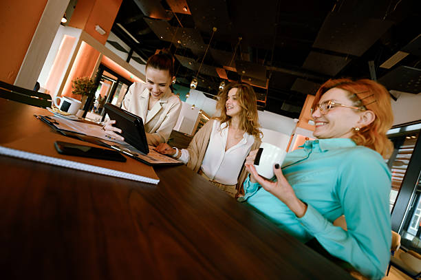 istock Businesswomen collaborate in a modern office setting while discussing ideas and sharing insights over coffee during a productive morning meeting 2221564556