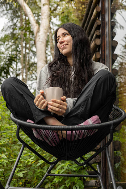istock Smiling in Lotus Pose with a Warm Drink in the Jungle 2221568832