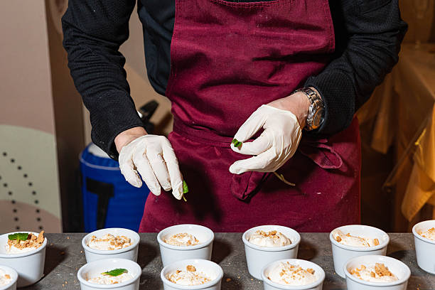 istock Chef decorating dessert cups with fresh mint. 2221568840