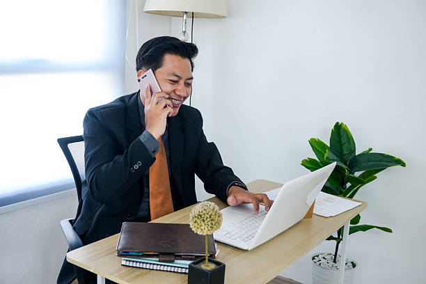 istock Businessman Using Laptop and Talking on Phone 2221573819