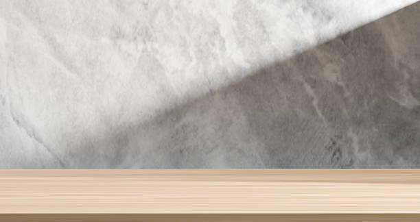 istock Empty wooden surface with grey concrete textured wall and subtle shadow, perfect as a minimalist product display or natural backdrop. Ideas for showcasing items in rustic, industrial, or modern themes 2221586010