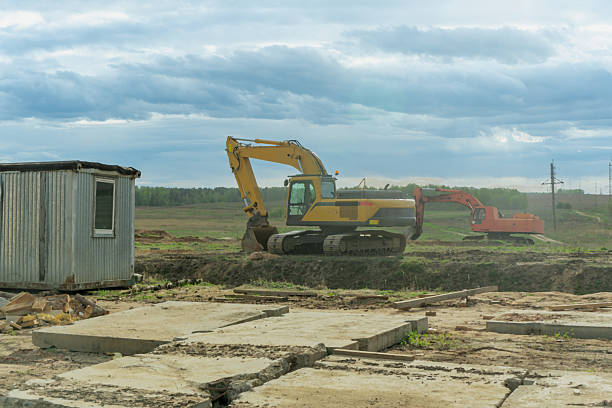 Dynamic Construction Site: Heavy Machinery in Action Under a Dramatic Sky. Innovative Infrastructure Development: Excavators and Bulldozers Transforming the Landscape.