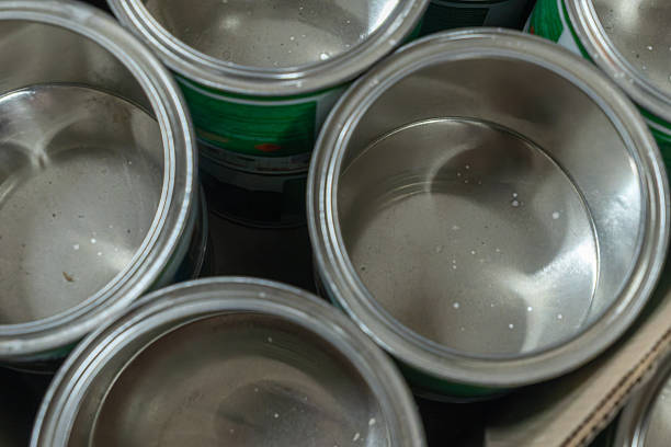 istock Rows of empty tin cans prepared for vibrant paint production. Empty vessels awaiting paint. Empty tin cans lined up in a paint factory. Rows of empty paint cans in an industrial setting. 2221593325