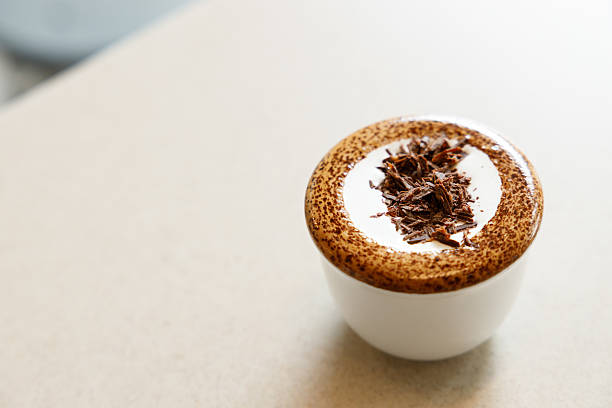 Cup of hot milk chocolate mocha coffee on table by the window. Selective focus.