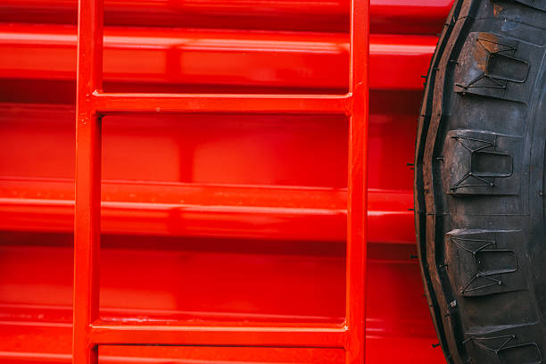 New shiny, red tractor with double wheels, blue sky with white clouds