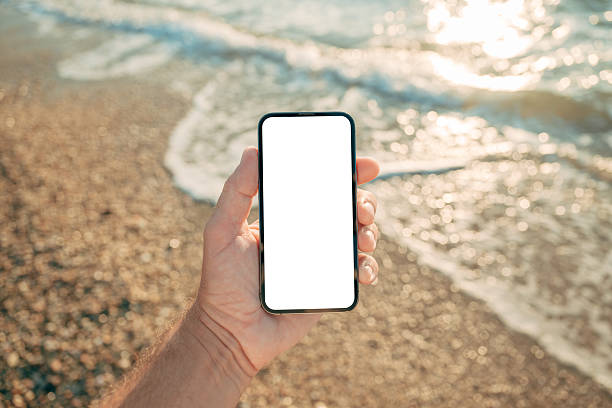 istock Mobile phone screen mockup, man with smartphone at ocean beach 2221597810