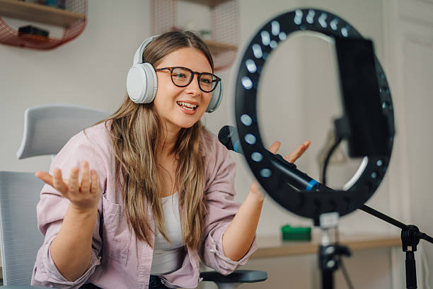 istock Young woman recording podcast, singing or making video call using ring light and microphone 2221602404
