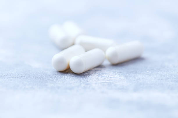 istock Creatine capsules on bright wooden background. Soft focus. Close up. Copy space 2221606348