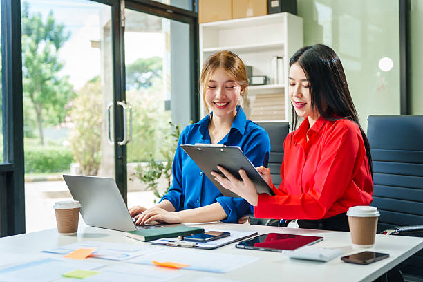 istock Two young female business consultants work on startup, collaborating on mobile app development social media strategies. whiteboards, documents, they aim to build a successful e-commerce business. 2221608579