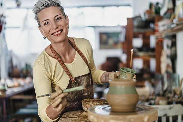 istock Pottery artist coloring a clay flower pot 2221615913