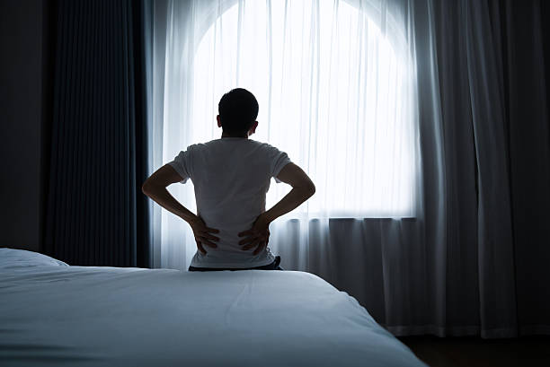 istock Man sitting on the bed with backache 2221616530