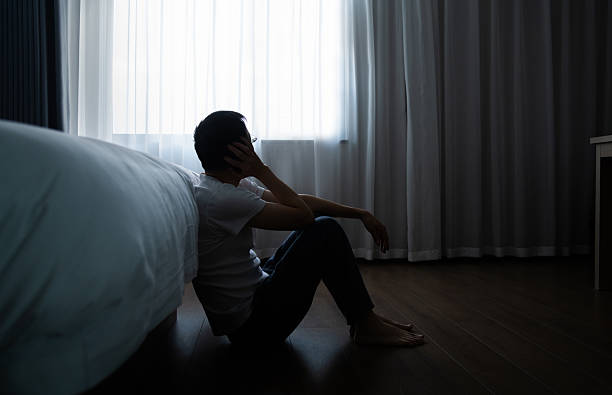 istock Depressed man sitting on bedroom floor 2221616540