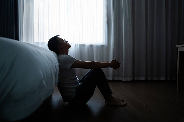istock Depressed man sitting on bedroom floor 2221616545