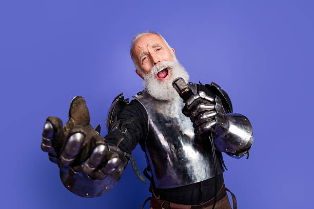 istock Medieval knight performing passionately with a microphone, elderly man in armor with a vibrant expression against a violet backdrop 2221618493