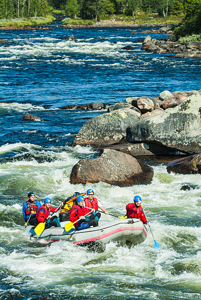 A group of people white water rafting on the Zambezi River. The Zambezi River is known for its challenging Class III to V rapids.