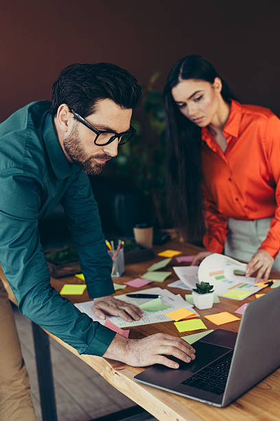 istock Focused office collaboration with coworkers discussing project details, reviewing documents. 2221619320