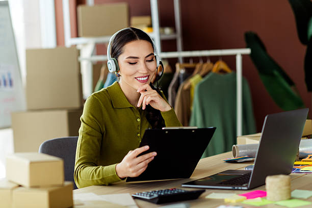 istock Young female entrepreneur working in a modern atelier workspace using laptop and documents, embodying style and professionalism 2221619492