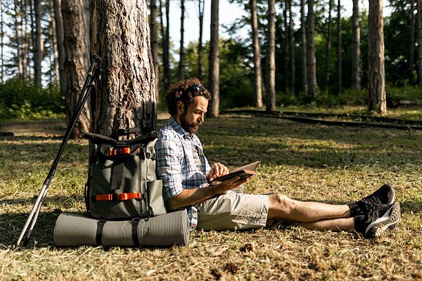 istock Handsome Outdoor Enthusiast Reading During Summer Hike 2221627410