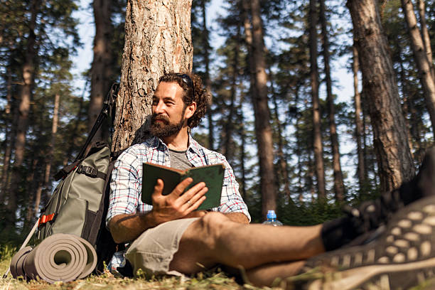 istock Young Hiker with Backpack Enjoying a Book in Nature 2221627420