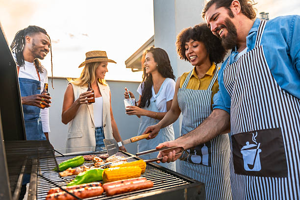 istock Friends cooking barbecue together on rooftop at sunset 2221627536