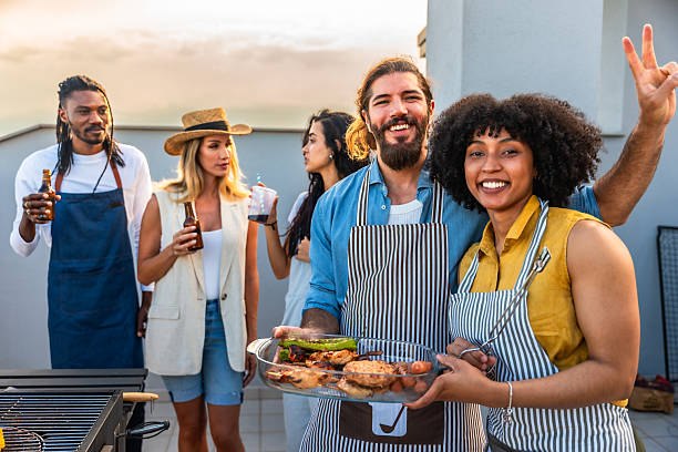 istock Happy friends making barbecue and drinking beer at rooftop party 2221628093