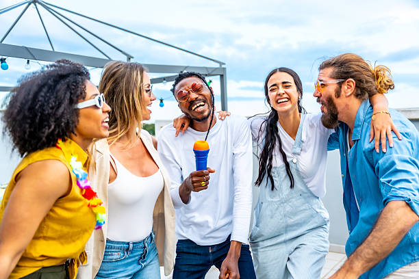 istock Friends singing karaoke at rooftop party, having fun 2221628265
