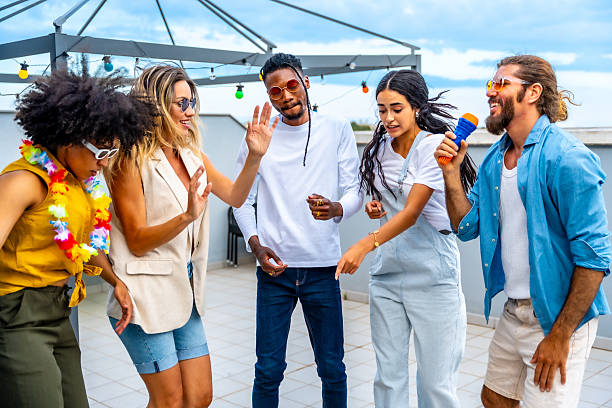istock Friends singing and dancing at rooftop party 2221628271