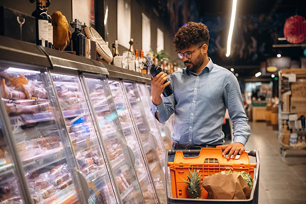 istock Bottle in hand. Man is in the grocery store 2221628434