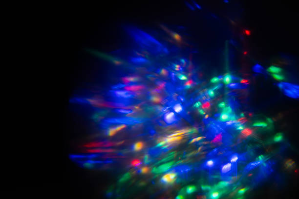 Abstract blurred colorful lens flare bokeh on black.