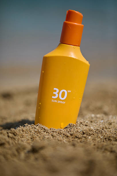 istock Sunscreen bottle with SPF  on a sandy beach, ideal for summer sun protection. 2221634159