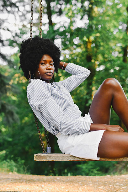 istock Female Sitting On Swing Looking Straight At Camera With Focused And Serious Expression 2221634470