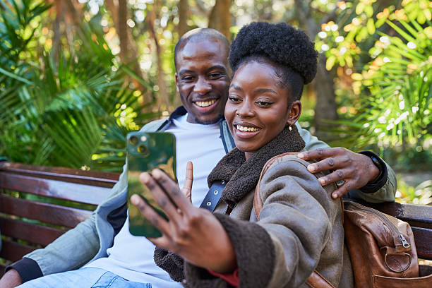 istock Happy Couple Taking a Selfie Together in a Sunlit Park Setting With Lush Greenery 2221634629