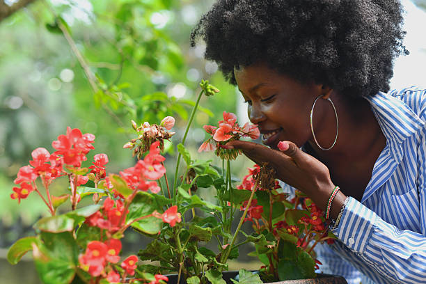 Beautiful Female Smiling Softly While Smelling Colorful Flowers