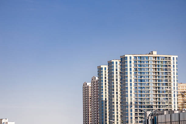 istock Front view of a white modern skyscraper perfect symmetry with blue sky and copy space. Architecture background concept 2221637542