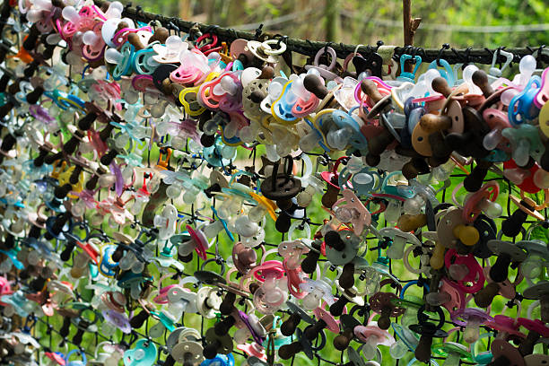istock Colorful baby pacifiers on the fence 2221639514