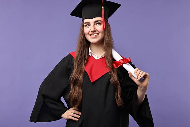 istock Happy student with diploma after graduation on violet background 2221643262