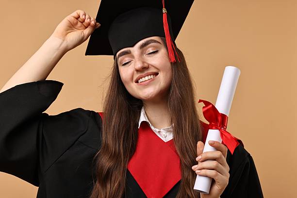 istock Happy student with diploma after graduation on beige background 2221643270