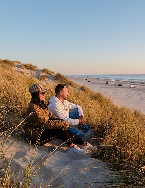 Couple enjoying a serene sunset view on the beach in Denmark