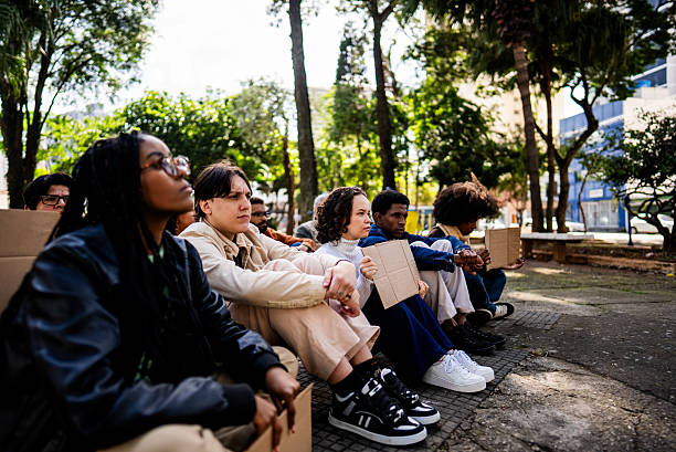 People sitting on ground during protest outdoors