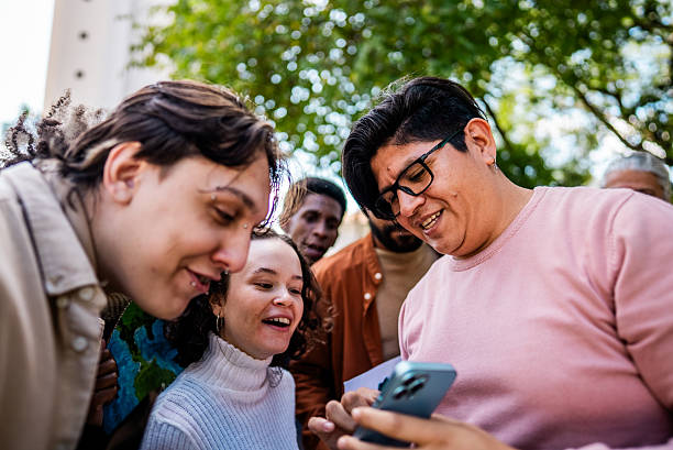 istock Friends talking and using mobile phone outdoors 2221656295