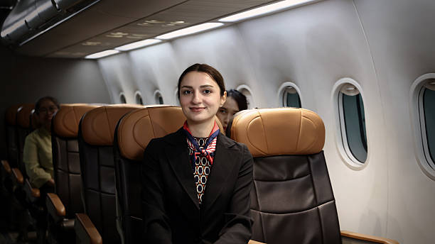 istock Air hostess. Smiling flight attendant in uniform welcomes and guides passengers aboard a modern airplane. Friendly airline staff providing professional service and comfortable travel flight experience 2221657588