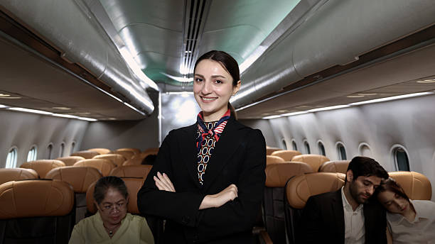 istock Air hostess. Smiling flight attendant in uniform welcomes and guides passengers aboard a modern airplane. Friendly airline staff providing professional service and comfortable travel flight experience 2221657641