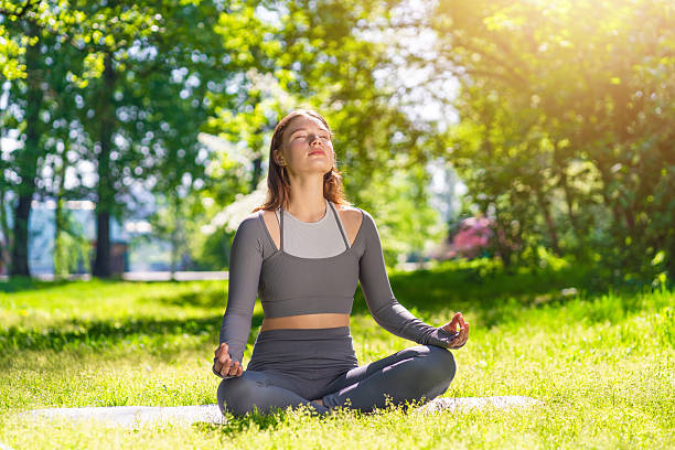istock Practicing yoga in a serene park setting during a sunny afternoon 2221658569